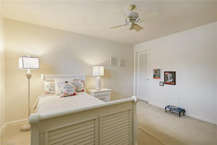 Bedroom with light colored carpet, baseboards, a ceiling fan, and a closet