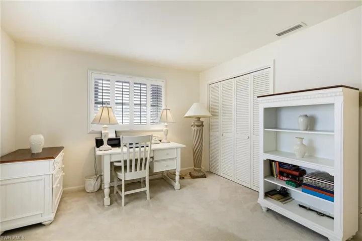 Office area featuring light carpet and baseboards