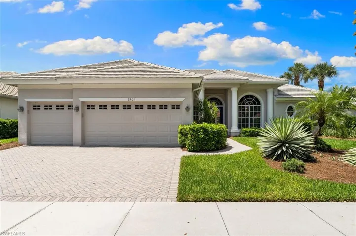 View of front of property featuring an attached garage, decorative driveway, and stucco siding