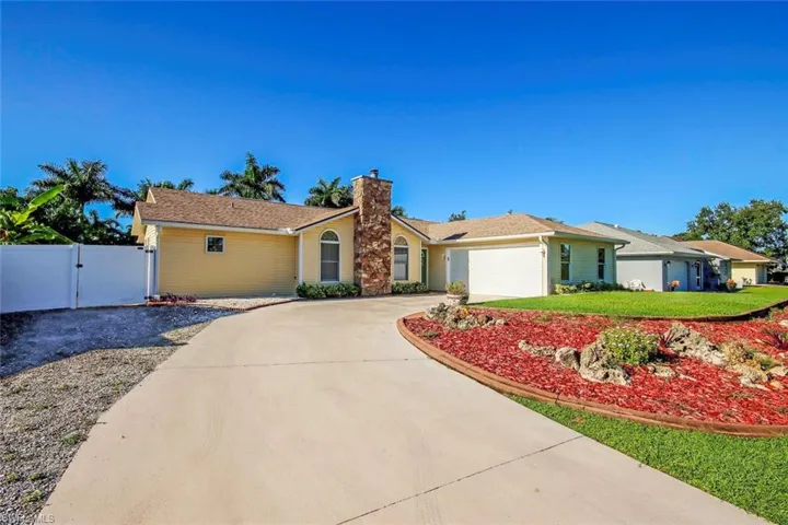 Ranch-style home with a gate, driveway, a chimney, and a garage