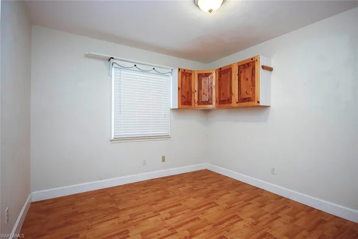 Spare room featuring light wood-style flooring and baseboards