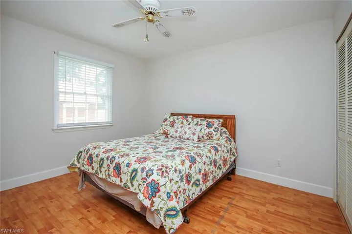 Bedroom with light wood-style floors, ceiling fan, and a closet