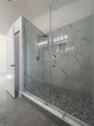 Bathroom featuring walk in shower and tile patterned flooring