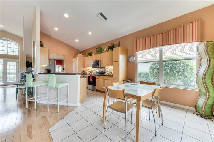Dining room featuring light wood finished floors, plenty of natural light, visible vents, and baseboards