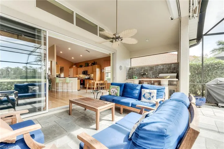 View of patio / terrace featuring a ceiling fan, area for grilling, glass enclosure, grilling area, and an outdoor living space