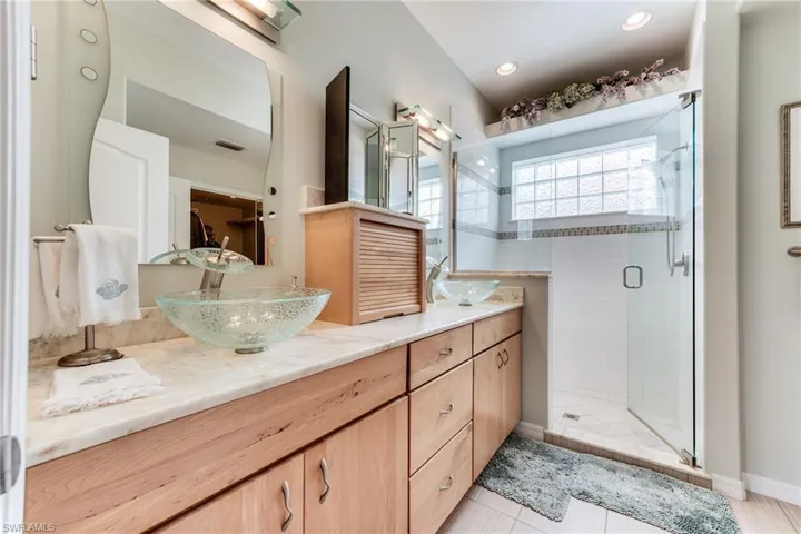 Full bathroom featuring double vanity, a stall shower, a sink, and visible vents