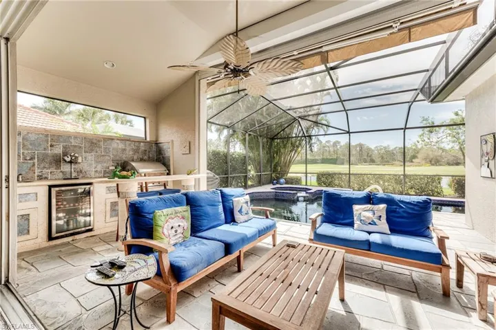 Sunroom / solarium featuring beverage cooler, ceiling fan, and vaulted ceiling