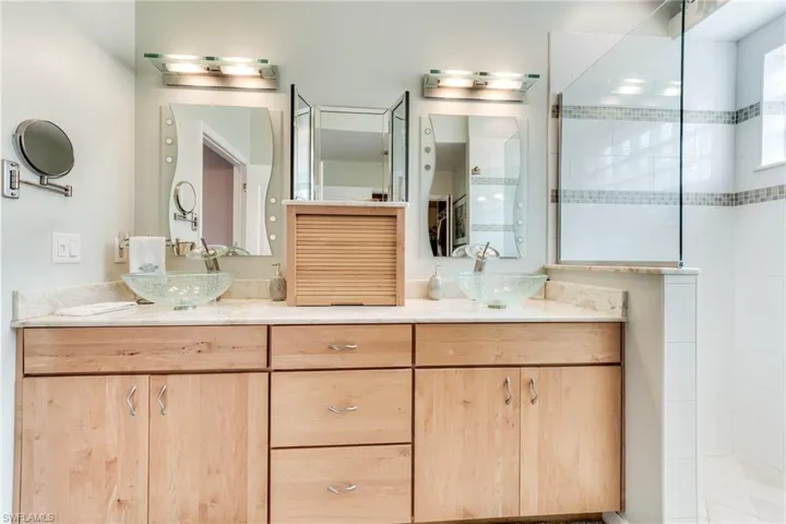 Bathroom featuring double vanity, a walk in shower, and a sink
