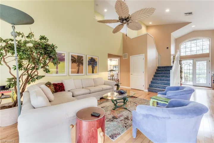 Living area featuring visible vents, stairway, and wood finished floors