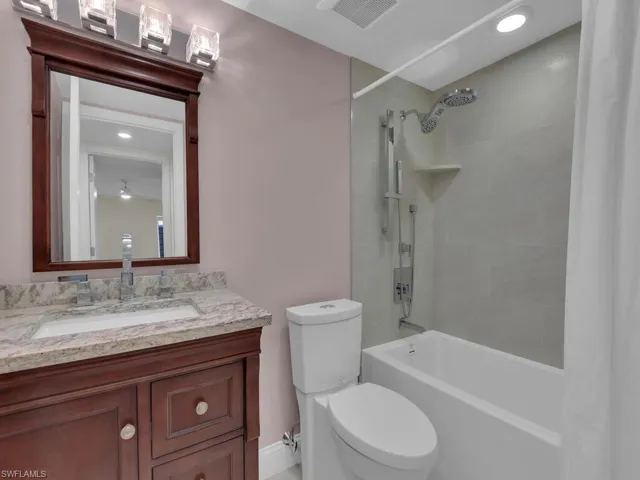 Full bathroom with shower / tub combo, vanity, and toilet
