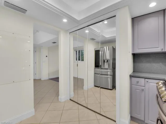 Kitchen with decorative backsplash, light tile patterned flooring, ornamental molding, and appliances with stainless steel finishes