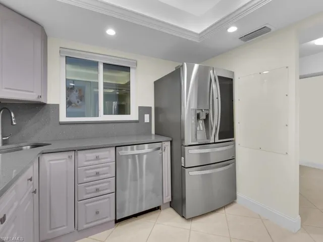 Kitchen featuring light tile patterned floors, backsplash, stainless steel appliances, and sink