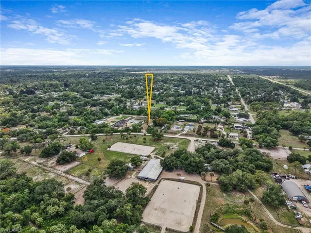 Expansive aerial perspective showcasing a rural landscape with dense tree coverage and scattered residential structures