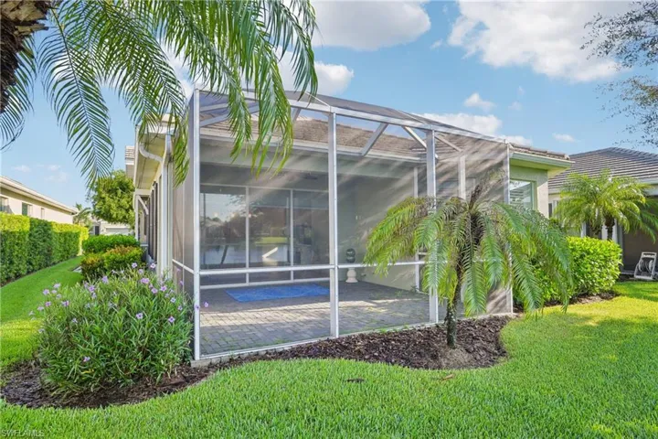 Rear view of house with a yard, a patio area, and glass enclosure
