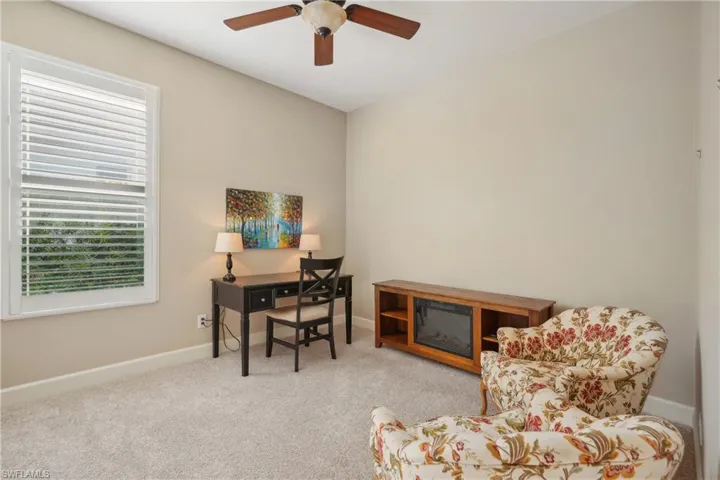 Carpeted office space featuring ceiling fan