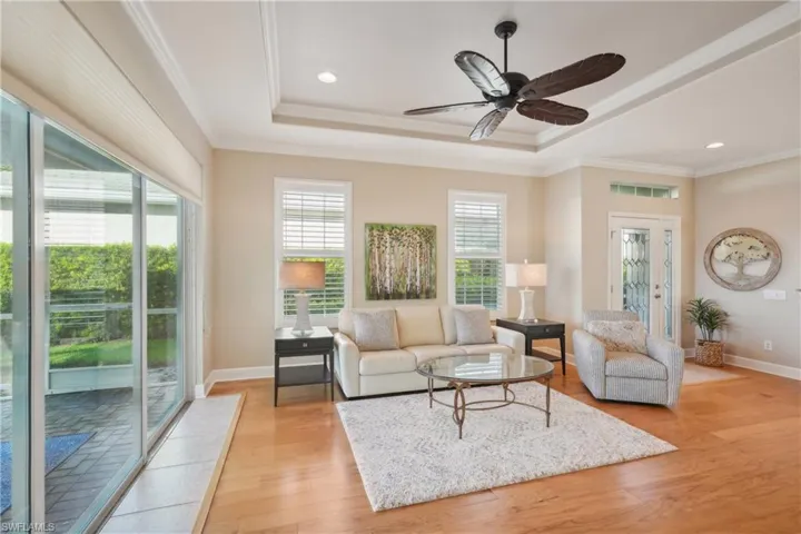 Living room featuring crown molding, light hardwood / wood-style flooring, and ceiling fan