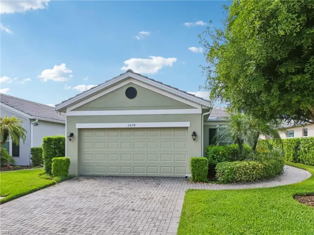 Ranch-style house featuring a garage and a front lawn
