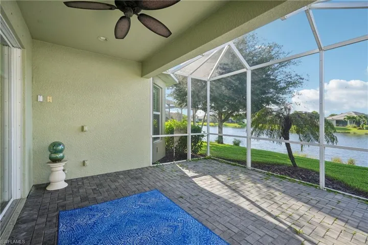 Unfurnished sunroom with ceiling fan and a water view