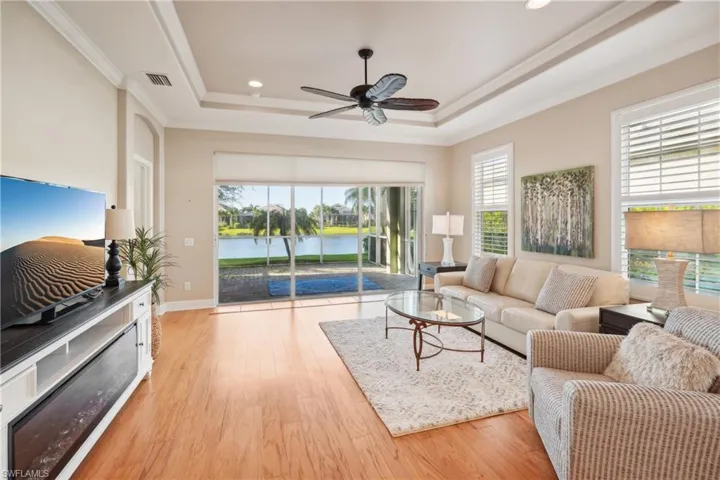 Living room with light wood-type flooring, ceiling fan, and plenty of natural light
