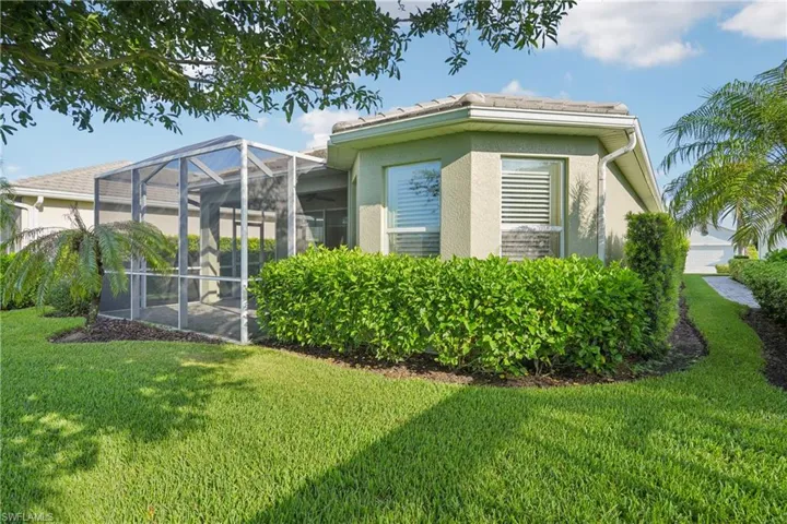 Back of property featuring a lawn and a lanai
