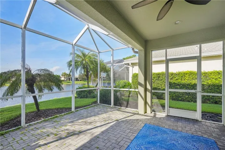Unfurnished sunroom featuring a water view and ceiling fan