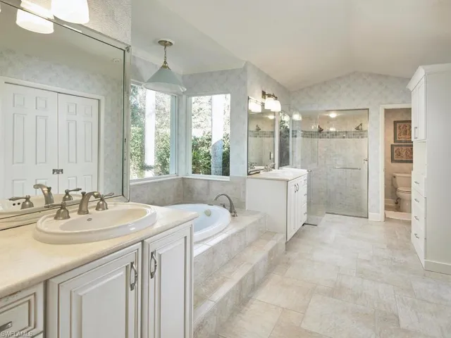 En suite primary bathroom with walk-in shower and soaking tub.