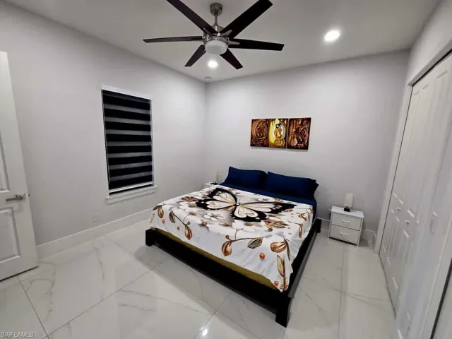 Bedroom with a closet, recessed lighting, ceiling fan, and light marble finish floors