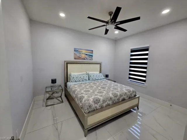 Bedroom with ceiling fan, recessed lighting, and light marble finish flooring