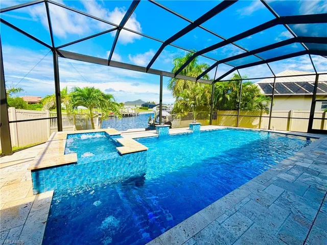 Combined pool / hot tub featuring a lanai, a sunroom, a water view, and a patio area