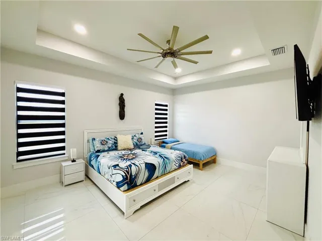 Bedroom with a ceiling fan, recessed lighting, and marble finish flooring
