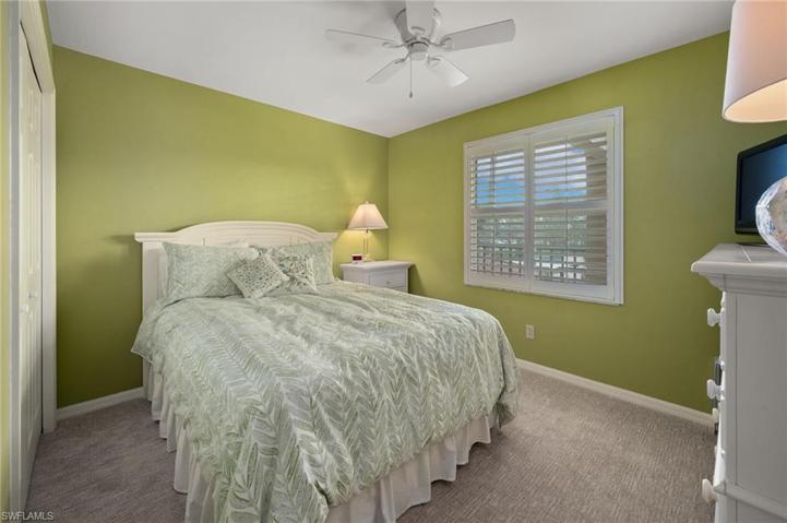 Guest bedroom with plantation shutters and impact window