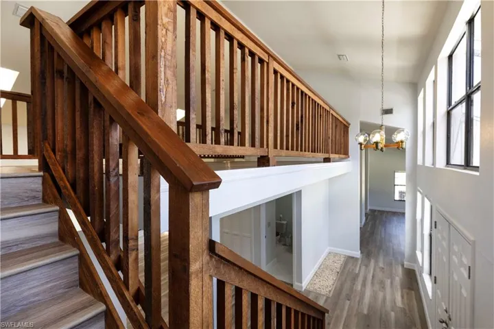 Staircase with a chandelier and wood finished floors