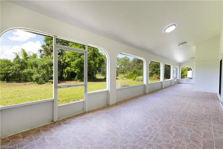 Unfurnished sunroom with lofted ceiling