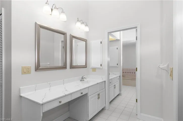 Bathroom with vanity, tile patterned flooring, and a closet