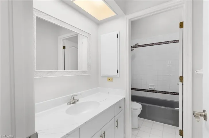 Full bath featuring vanity, shower / tub combination, and tile patterned floors