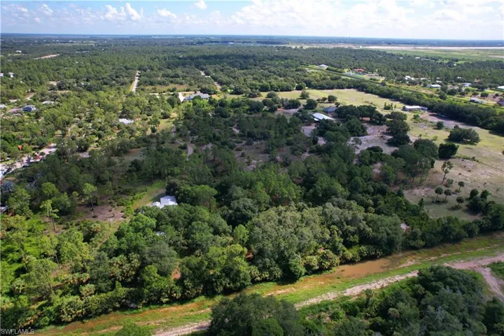 View of property location with a heavily wooded area