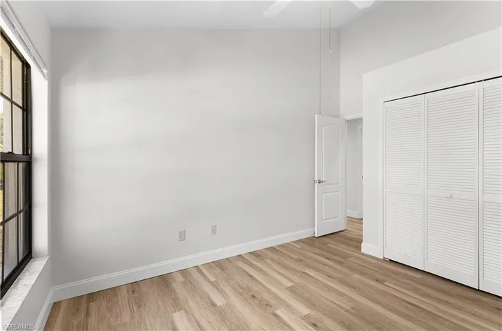 Unfurnished bedroom with light wood-style flooring, a closet, and ceiling fan