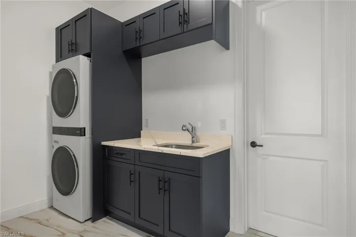 Laundry room with cabinet space and estacked washer and dryer