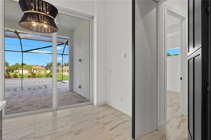 Doorway featuring marble look tiles and a sunroom
