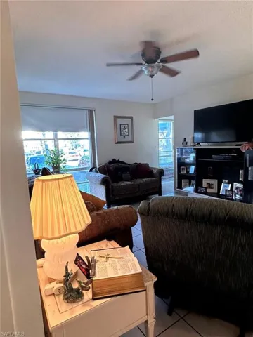 Living area featuring tile patterned flooring and ceiling fan