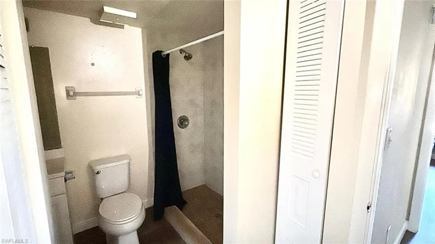 Full bath with a closet and a shower stall