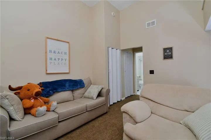Carpeted living room featuring a high ceiling