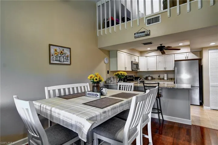 Dining area with a high ceiling, ceiling fan, and hardwood / wood-style floors