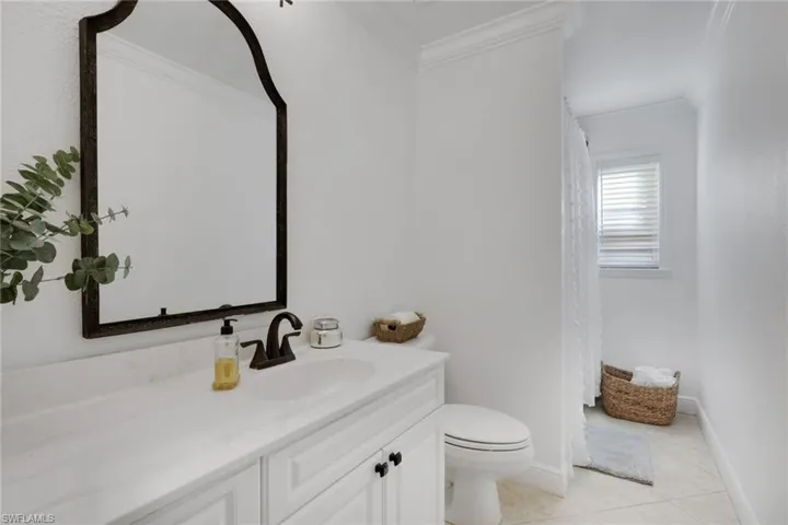 Bathroom featuring ornamental molding, a shower with shower curtain, light tile patterned floors, and vanity
