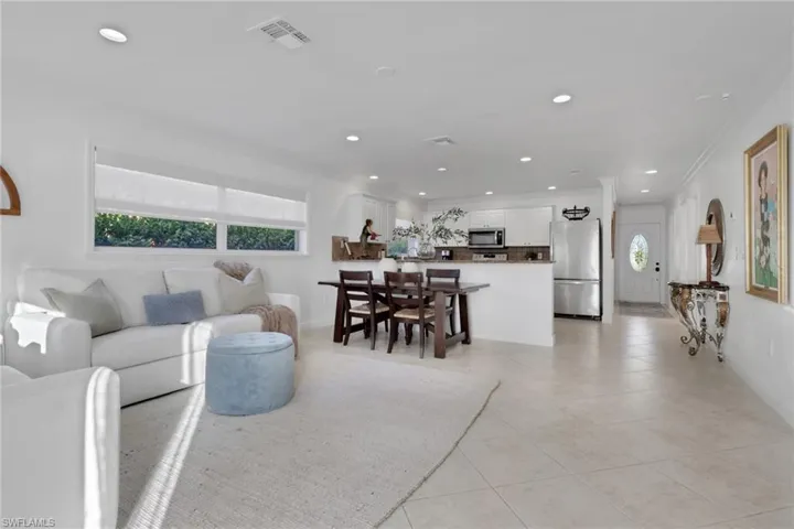 Living area featuring recessed lighting, light tile patterned floors, and ornamental molding