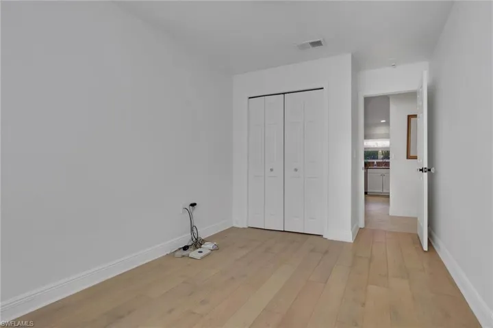 Unfurnished bedroom with light wood-style flooring and a closet