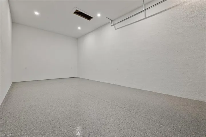 Garage with recessed lighting and a textured wall
