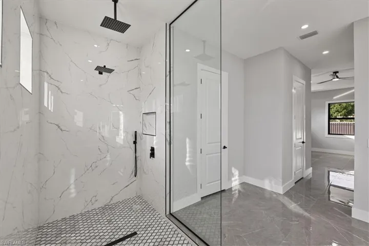 Bathroom with a marble finish shower, a ceiling fan, marble tiled floors, and recessed lighting