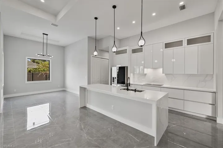 Kitchen with white cabinetry, glass insert cabinets, modern cabinets, dark marble finish floors, and recessed lighting