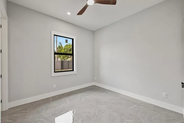 Empty room featuring baseboards and ceiling fan